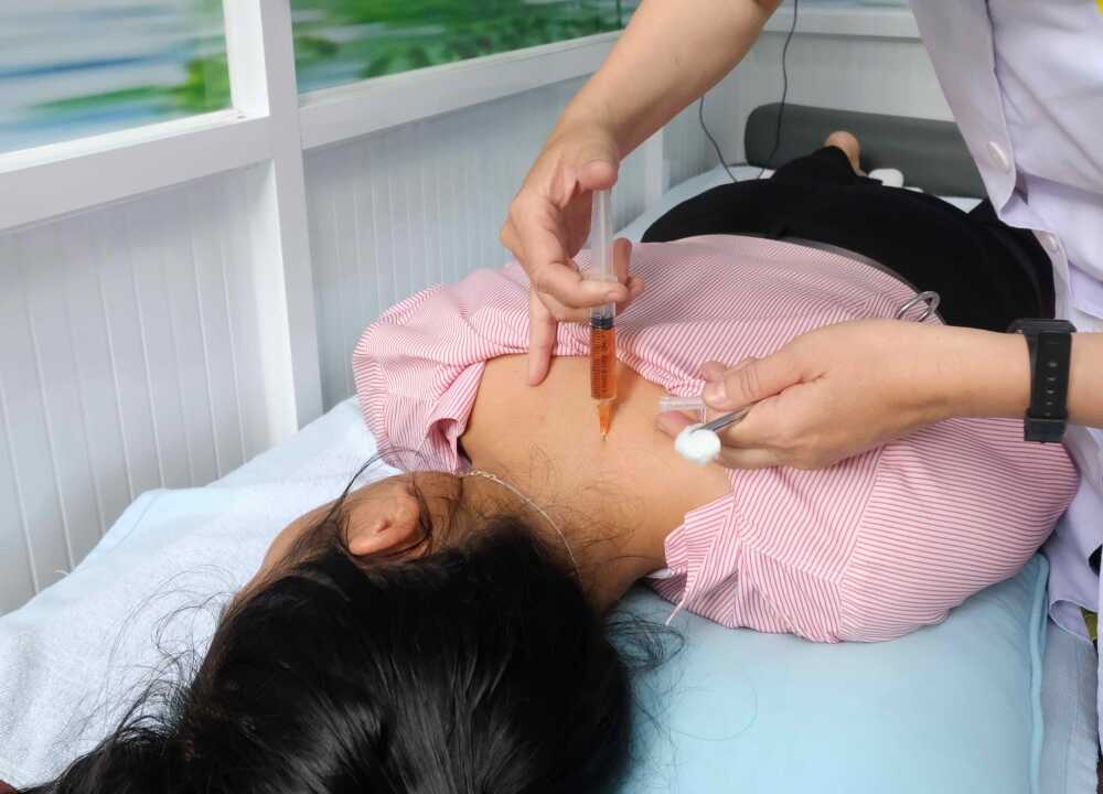 Bác sĩ thực hiện kỹ thuật thủy châm vitamin vào huyệt đạo vùng cổ vai gáy