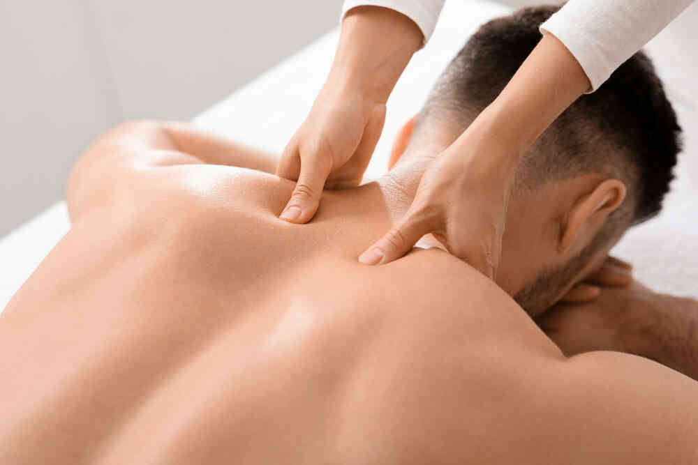 Kỹ thuật viên thực hiện xoa bóp bấm huyệt vùng cổ vai gáy trị liệu đau mỏi